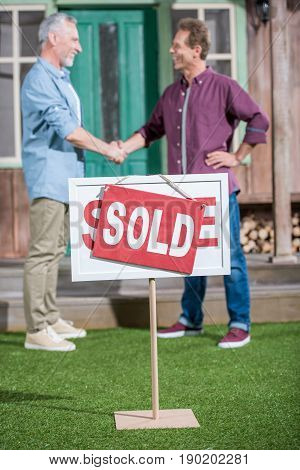 Men Shaking Hands With Saleman And Buying New House