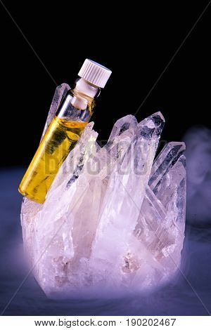 Detail of cannabis oil container and quartz crystal isolated on black - medical marijuana concept