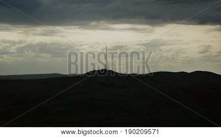 Silhouette of the hills and the TV tower. Silhouette of the TV tower. Silhouette of the hills. Natural background. Television tower. Horizon.