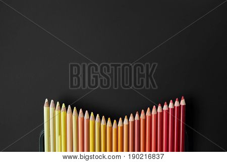 Colour pencils isolated on black background close up