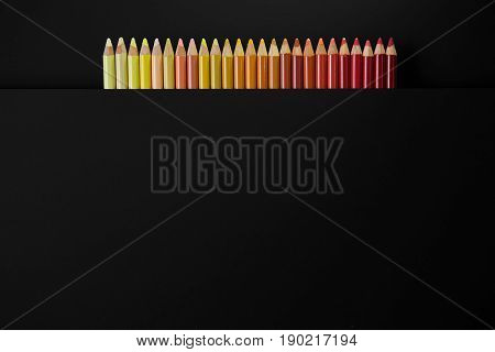 Colour pencils isolated on black background close up