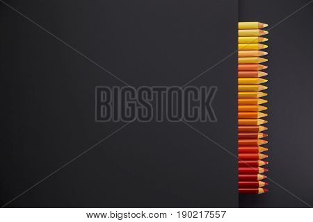 Colour pencils isolated on black background close up