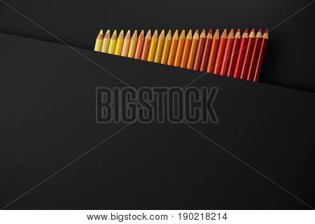 Colour pencils isolated on black background close up
