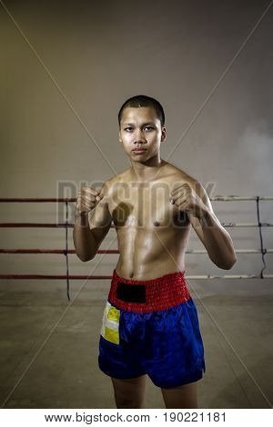 Portrait man Professional Muay Thai a strong ready for the fight in the fight of Muay Thai. This is a Martial art of Thailand and the world. Muay Thai boxer International extreme sport.