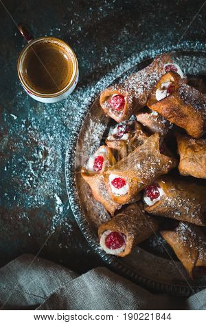 Italian traditional cannoli with cherry on a tin plate close-up vertical