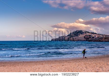 Mediterranean beach at the sunset and a lonely girl