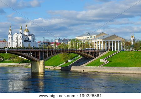 VITEBSK BELARUS - MAY 16 2017: Beautiful view of Western Dvina River Holy Dormition Cathedral and National Academic Drama Theater named after Yakub Kolas Vitebsk Belarus