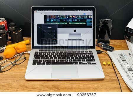 PARIS FRANCE - JUNE 6 2017: Apple Computers website on MacBook Retina in creative environment showcasing latest news from Apple at WWDC 2017 - Promise pegasus thunderbolt dock nas next to imac