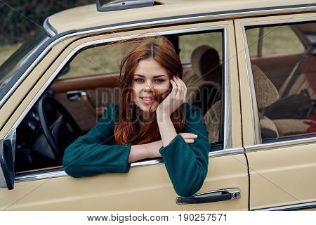 Beautiful young woman in the car, a woman is riding in a retro car.