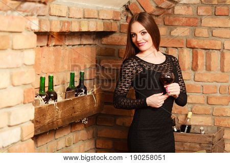 Woman Tasting Wine In Rural Cottage Interior