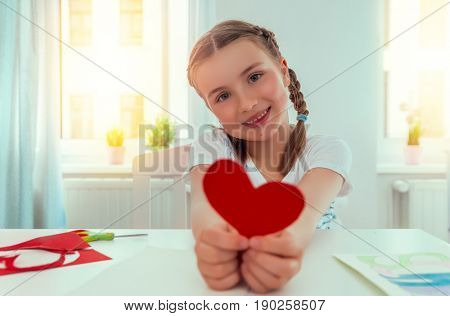 girl surprising parents with greeting card at home
