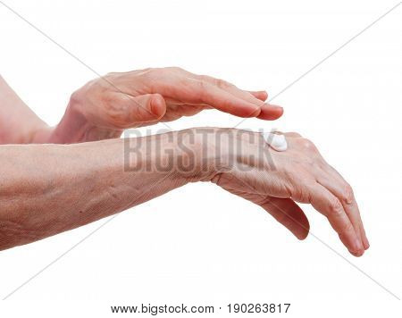 Hands of an elderly woman with moisturizing cream. Care of the old skin. Isolate on a white background.
