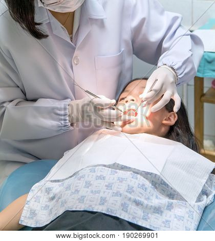 Young Asian child having dental professional treatment in stomatology clinic. Admirable pre teen girl visiting her dentist for teeth checkup.