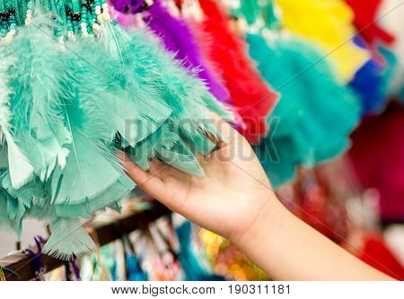 OTAVALO, ECUADOR - MAY 17, 2017: Close up of a woman holding a magenta catchdreamer in her hand, in colorful market background.