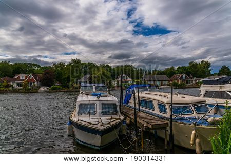 Boats Anchored On The Bank Of The River, Residential Houses On The Other Side, Beautiful Broad River
