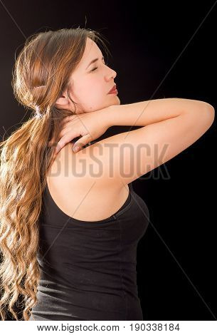 Beautiful young lady Suffer crick after workout in a black background.
