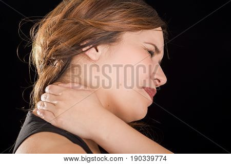 Close up of a beautiful young lady Suffer crick after workout in a black background.