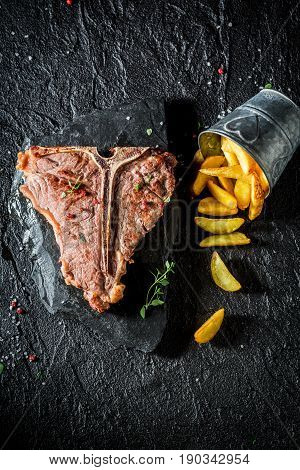 Closeup Of Tbone Steak With Chips On The Black Rock
