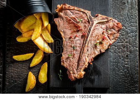 Homemade Tbone Steak With Chips On The Burnt Table