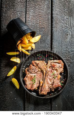 Closeup Of Chips And Tbone Steak On The Burnt Table
