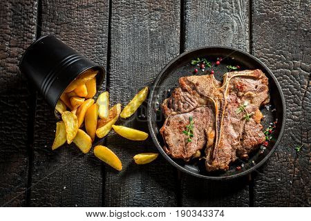 Closeup Of Fresh Tbone Steak And Chips With Herbs