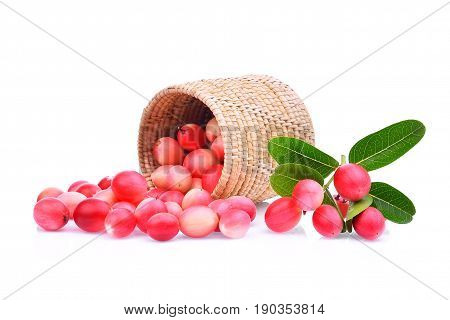 karanda or carunda tropical fruit in wooden basket with green leaves isolated on white background