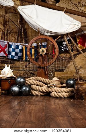 Pirates ship deck with steering wheel and flag.