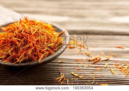 Spice saffron in a wooden spoon on the table. Close-up.