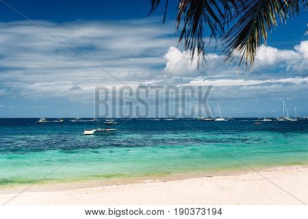 Tropical beach with palm trees yacht sailing boats blue sky turquoise water and white sand. Paradise relaxing. Philippines Boracay. horizontal