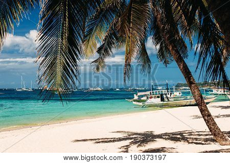 Tropical beach with palm trees pilippine boats blue sky turquoise water and white sand. Paradise relaxing. Philippines Boracay. horizontal