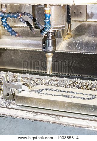 Industrial metal mold/blank speed drilling. Metalworking mechanical engineering lathe and milling technology. Indoors vertical image.