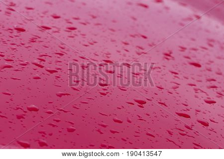 Drops of water on the red car roof color, nature background