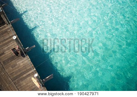 Wooden jetty with crystal clear and turquoise sea water of the tropical sea . Aerial top view .Rawa island Malaysia .