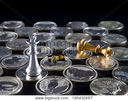 Silver chessboard silver and gold chess silver coins with black background homeless sitting on the bank