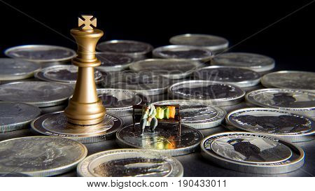 Silver chessboard silver and gold chess silver coins with black background homeless sitting on the bank