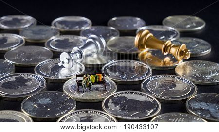 Silver chessboard silver and gold chess silver coins with black background homeless sitting on the bank