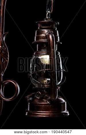 antique bronze iron-shod chandelier isolated on black background. Large chandelier for the living room interior, close-up