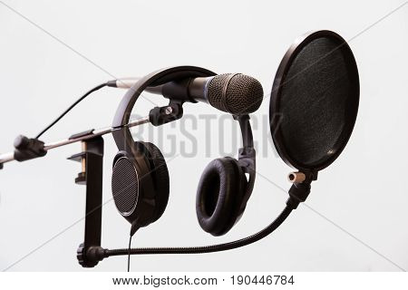 Cardioid condenser microphone, headphones and pop filter on a gray background. Home recording Studio.