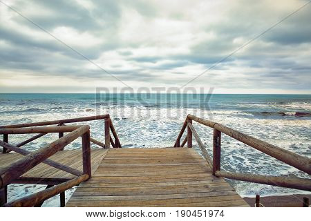 wooden foot bridge on a churning sea