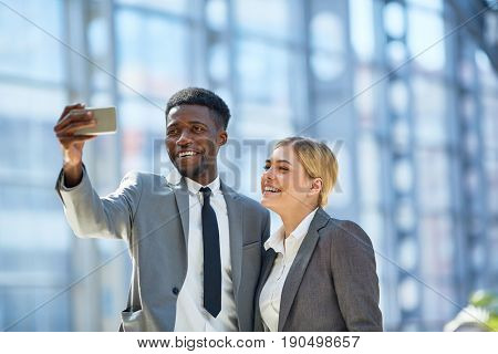 Friendly colleagues making selfie at break