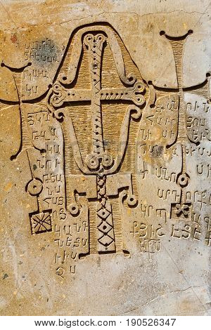 Christian carved bas-relief. On the stone placed the ornament with the Christian cross and the Armenian text.