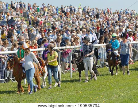 STOCKHOLM SWEDEN - JUNE 06 2017: Young jockeys warming up the pony gallop race horses at Nationaldags Galoppen at Gardet. June 6 2017 in Stockholm Sweden