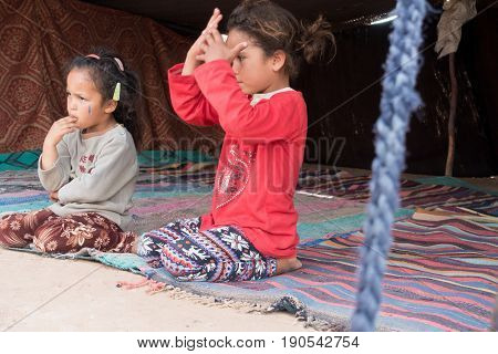 Merzouga Desert Morocco - May 09 2017: Two young Moroccan Berber girls sitting in a Berber tent in the Sahara desert.