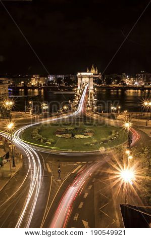 Long-exposure night shot of a square a bridge and their traffic