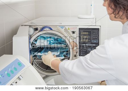 Denatal assistant using Sterilization systems. Preparation instruments for cleaning.