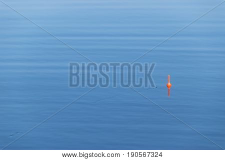 Fishing float with the line on the blue water