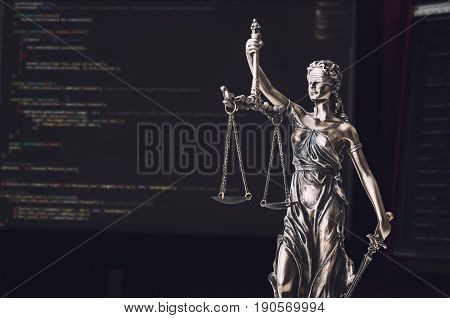 Justice Statue With Code On Screen In Background