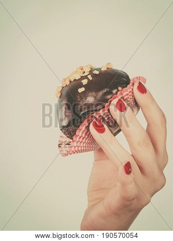 Woman Hand Holding Chocolate Cupcake About To Bite