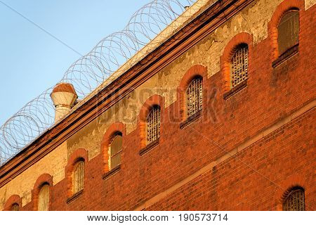 The outside view of an old and abandoned jail in Berlin during sunset
