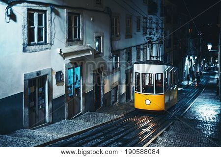 Yellow empty popular old touristic tram on ancient street of Lisbon Portugal with beautiful light reflections during deep night with copy space place for your logo text or advertising messages